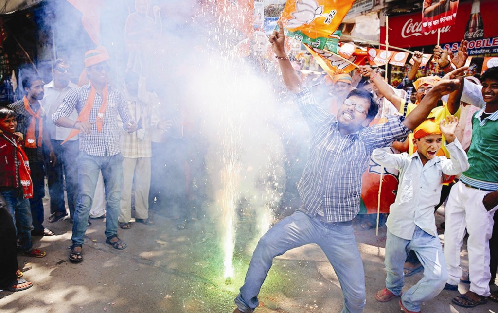 BHARATIYA JANATA PARTY (BJP) SUPPORTERS DANCE AND BURST FIRECRACKERS TO CELEBRATE THE NEWS OF EARLY ELECTION RESULT TRENDS IN ALLAHABAD, UTTAR PRADESH.